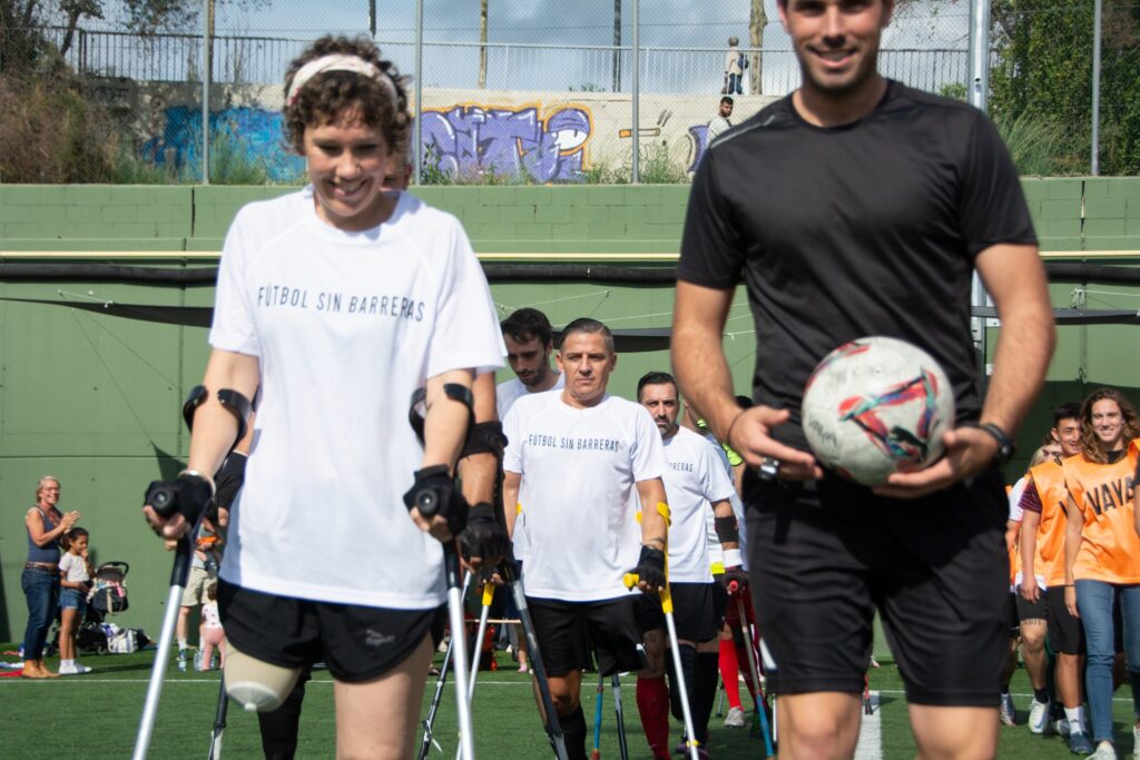 Jugadores con muletas entrando al campo de fútbol en Barcelona con árbitro